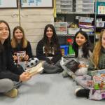 Sequim Gazette photo by Matthew Nash/ Kaylyn Baery, a sophomore, on left, takes turns reading with Helen Haller Elementary fourth graders, second from left, Aislyn Gockerell, Alinnea Martinez, Sophia Sims, and Aurora Pace.