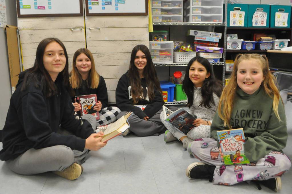 Sequim Gazette photo by Matthew Nash/ Kaylyn Baery, a sophomore, on left, takes turns reading with Helen Haller Elementary fourth graders, second from left, Aislyn Gockerell, Alinnea Martinez, Sophia Sims, and Aurora Pace.