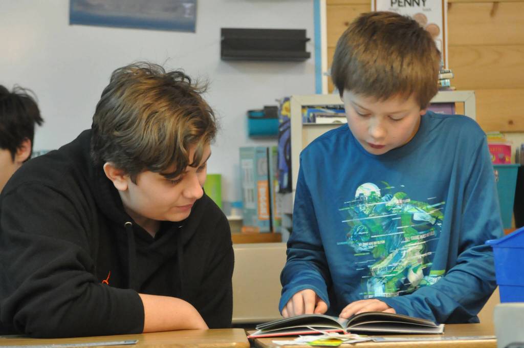 Sequim Gazette photo by Matthew Nash/ Third grader Kaleb Wright reads to Kaleb Permberton, an SHS freshman, on March 7.