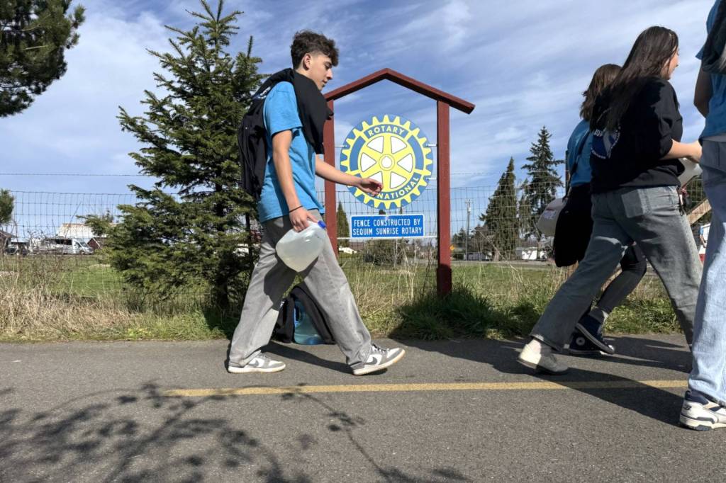 Photo by John Pehrson/ Along the Olympic Discovery Trail, 40 Sequim High School students walked with jugs and buckets on March 1 in solidarity with people across the globe who must walk long distances for drinking water.