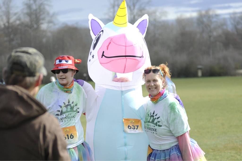 Sequim Gazette photo by Matthew Nash/ Matt and Lynette Wilson take a picture with Sherlyn Obermeit in a unicorn costume before the 1K Sun Fun Color Run on March 8.