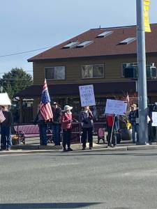 Photo by Lara Stanton| About 50 people, many holding signs, gathered at Sequim Avenue and Washington Street around lunchtime Friday to protest against President Donald Trump and his administration.