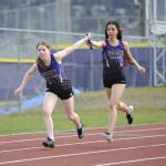 Sequim Gazette photo by Matthew Nash/ Shalom Eaton hands off to Maia Brewer in the 4X200 meters on March 20. They participated in the first race on Sequims track since 2021. It was resurfaced in July 2024.