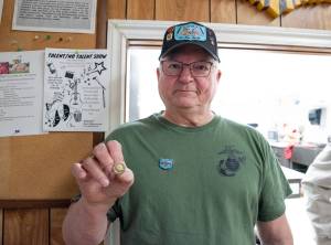 Sequim Gazette photo by Emily Matthiessen/ Featured speaker Daniel Abbott shows the Vietnam veteran lapel pin which was was given to local Vietnam veterans during Saturday's ceremony at the American Legion, Jack Grennan Post No. 62. The words "A grateful nation thanks and honors you" are embossed on the back of the pins, with an eagle set against the flag with a blue circle and laurel wreath and the words "Vietnam War Veteran" around it.
