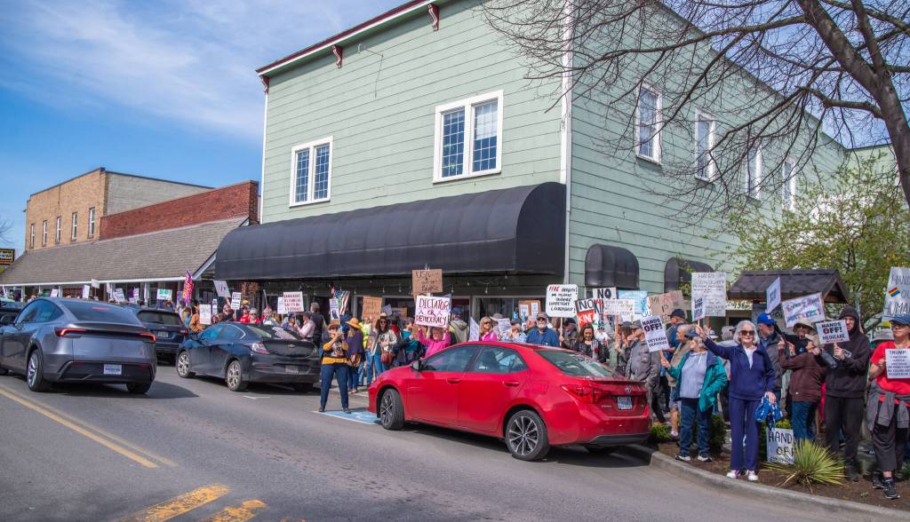 Sequim Gazette photo by Emily Matthiessen/ According to a clicker count by volunteers with Sequim Indivisible, 1298 people turned out by 11:45 a.m., with nearly 1400 people counted by 2:00 p.m. during Sequims version of the Hands Off  protests held across the nation and in other countries on Saturday. The protest was peaceful and orderly, according to police, organizers and protesters and featured a range of protest signs.