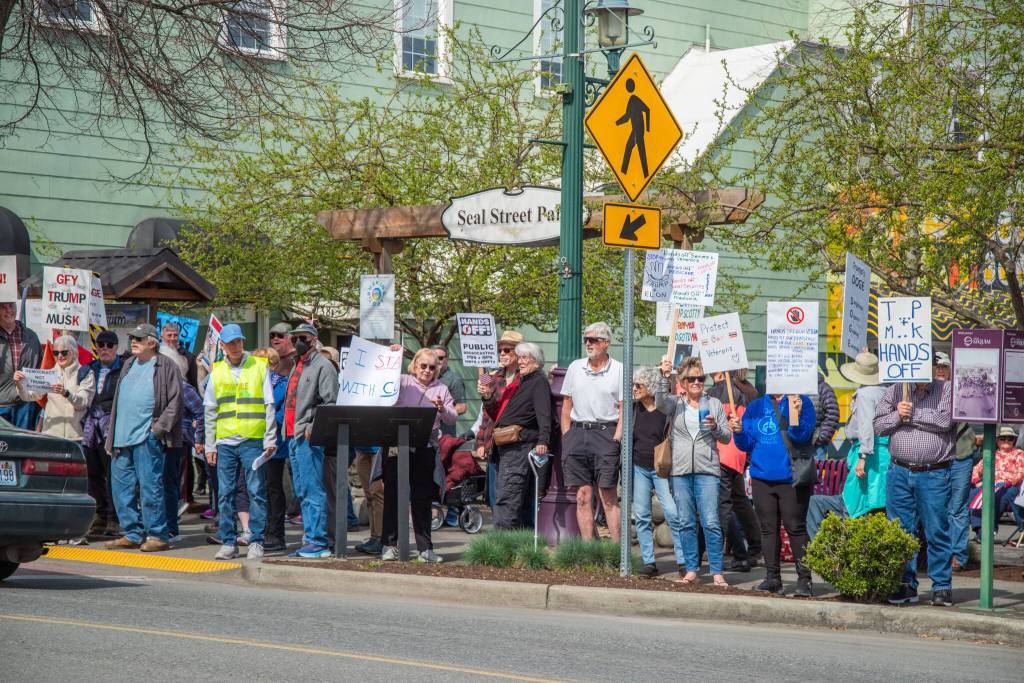 Sequim Gazette photo by Emily Matthiessen/ According to a clicker count by volunteers with Sequim Indivisible, 1298 people turned out by 11:45 a.m., with nearly 1400 people counted by 2:00 p.m. during Sequims version of the Hands Off  protests held across the nation and in other countries on Saturday. The protest was peaceful and orderly, according to police, organizers and protesters and featured a range of protest signs.