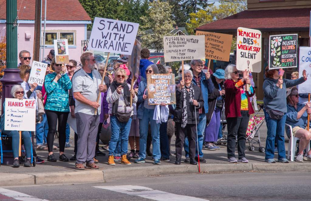 Sequim Gazette photo by Emily Matthiessen/ According to a clicker count by volunteers with Sequim Indivisible, 1298 people turned out by 11:45 a.m., with nearly 1400 people counted by 2:00 p.m. during Sequim's version of the "Hands Off " protests held across the nation and in other countries on Saturday. The protest was peaceful and orderly, according to police, organizers and protesters and featured a range of protest signs.
