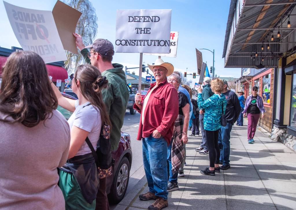 Sequim Gazette photo by Emily Matthiessen/ According to a clicker count by volunteers with Sequim Indivisible, 1298 people turned out by 11:45 a.m., with nearly 1400 people counted by 2:00 p.m. during Sequim's version of the "Hands Off " protests held across the nation and in other countries on Saturday. The protest was peaceful and orderly, according to police, organizers and protesters and featured a range of protest signs.