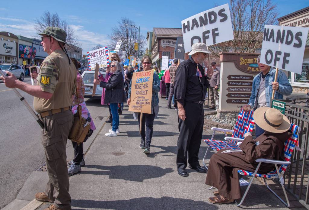 Sequim Gazette photo by Emily Matthiessen/ According to a clicker count by volunteers with Sequim Indivisible, 1298 people turned out by 11:45 a.m., with nearly 1400 people counted by 2:00 p.m. during Sequim's version of the "Hands Off " protests held across the nation and in other countries on Saturday. The protest was peaceful and orderly, according to police, organizers and protesters and featured a range of protest signs.