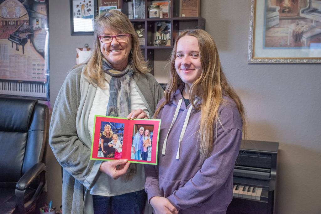 Sequim Gazette photo by Emily Matthiessen/ Piano teacher Dawn Martin holds photos of herself and one of her first students in Sequim, Avonlea Lawrence.