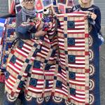 Sunbonnet Sue Quilt club Member Bonnie Cauffman, right, presents patriotic quilts made by members of the Sequim club to Betsy Reed Schultz, founder and executive director of Captain Joseph House Foundation in Port Angeles. The larger quilts will be used in Captain Joseph House, while the smaller comfort quilts will be presented to Gold Star family members. The Captain Joseph House Foundation is a one-of-a-kind 501(c)3 nonprofit that supports Gold Star Families of the U.S. militarys fallen war heroes since 9/11 from all branches of the military.<ins> The foundation looks to ensure a place for families of the fallen to gather for respite and to provide a continuum of care for their personal healing. For more about the Captain Joseph House Foundation, see <a href="https://captainjosephhousefoundation.org" target="_blank">captainjosephhousefoundation.org</a>. </ins>
