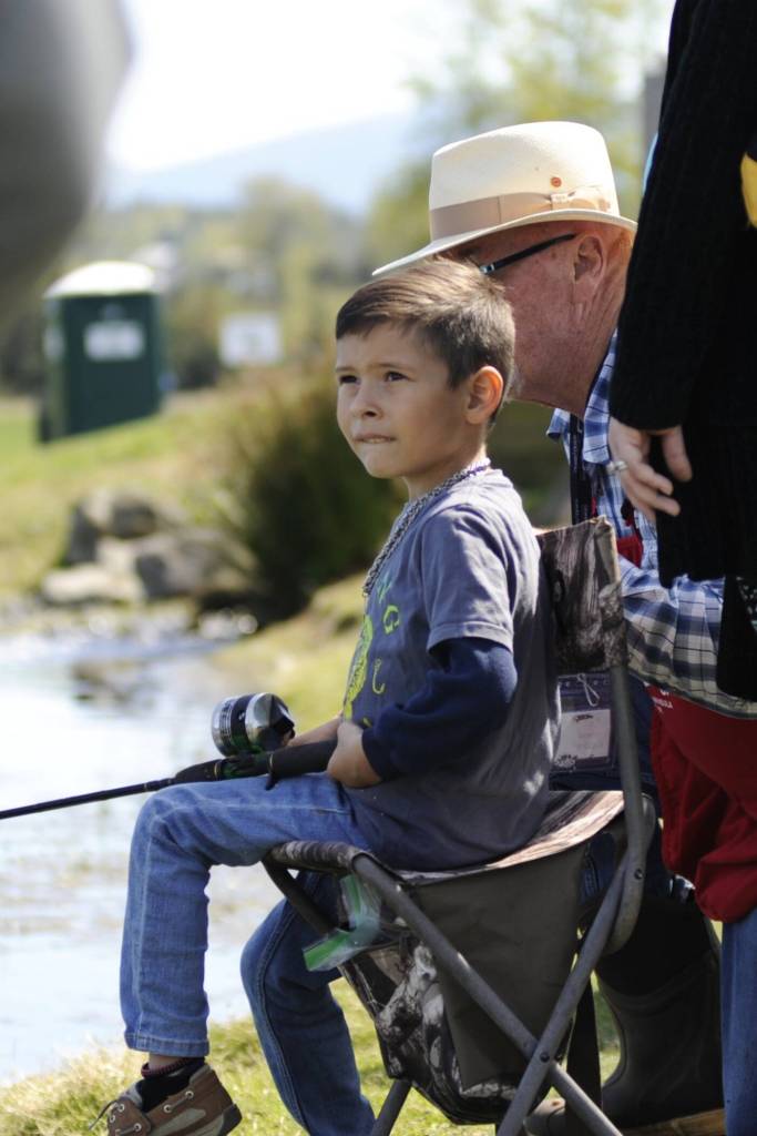 Elijah Martinez, 5, fishes with help from Denny Clawson from the North Olympic Peninsula Chapter of Puget Sound Anglers on April 18. Clawson has helped with Kids Fishing Day for three years, that includes an early fishing day for some Sequim students.