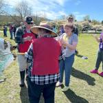 Sequim Gazette photo by Matthew Nash/ Megan Damon, third from left, with twin sister Madison, on right, celebrate her catching a fish on April 18. She and North Olympic Peninsula Chapter of Puget Sound Anglers volunteers reeled in a fish that Madison originally caught but it pulled her fishing pole out of her hands and into the water. Volunteers saw the bobber circling the pond and they and Madison reeled it in.