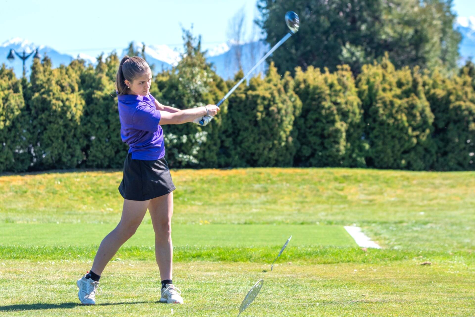 Sequims Raimey Brewer completes her swing and eyes her drive during the Wolves Olympic League girls golf match with Olympic at The Cedars at Dungeness on April 17.