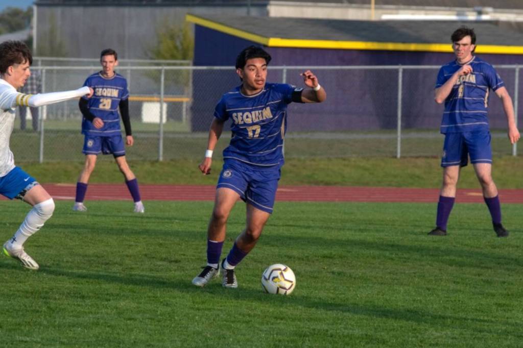 Sequim Gazette photo by Emily Mathiessen/ Evan Cisneros moves the ball up the field against Bremerton on April 18. The Wolves won 3-1.