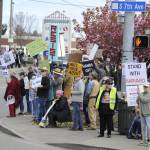 Sequim Gazette photo by Matthew Nash/ Residents line Washington Street and Seventh Avenue on April 19 to oppose changes made or proposed by President Donald Trump and his administration.