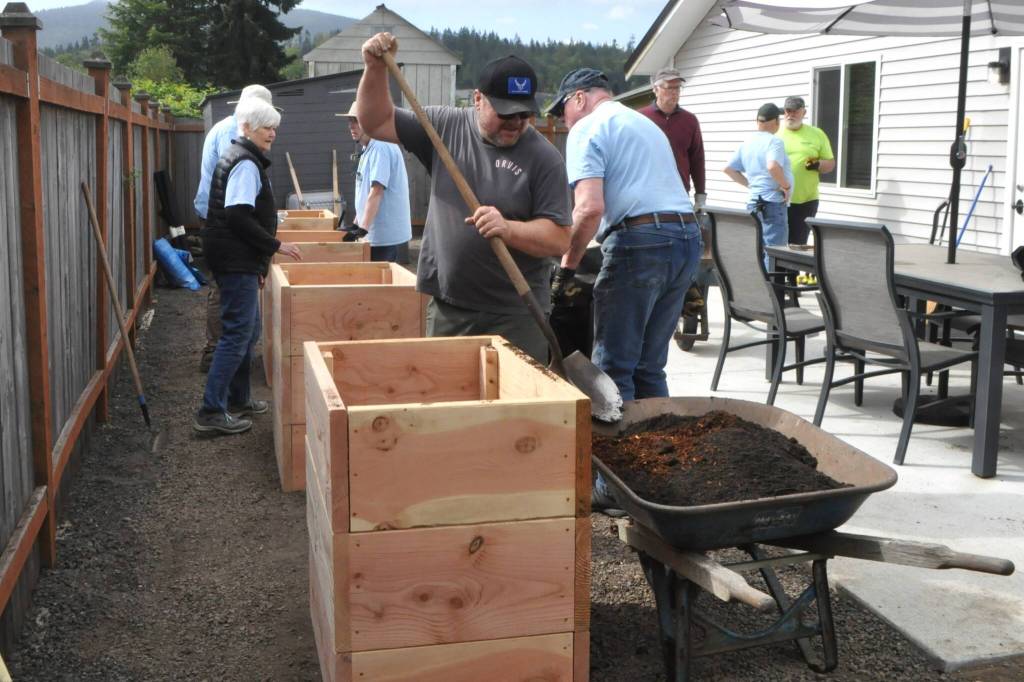 Kevin Harkins, a board member of Sarges Veterans Support, and volunteers from Sequim Community Church fill wheelchair-accessible planter boxes for LtCol James Minsky Place, a home for elderly and/or disabled veterans. Theyre accomplishing the impossible, Harkins said of efforts from businesses and volunteers. Large rocks were removed and a landscaping plan, bark, trees, flowers and bushes were all donated for the project, he said.
