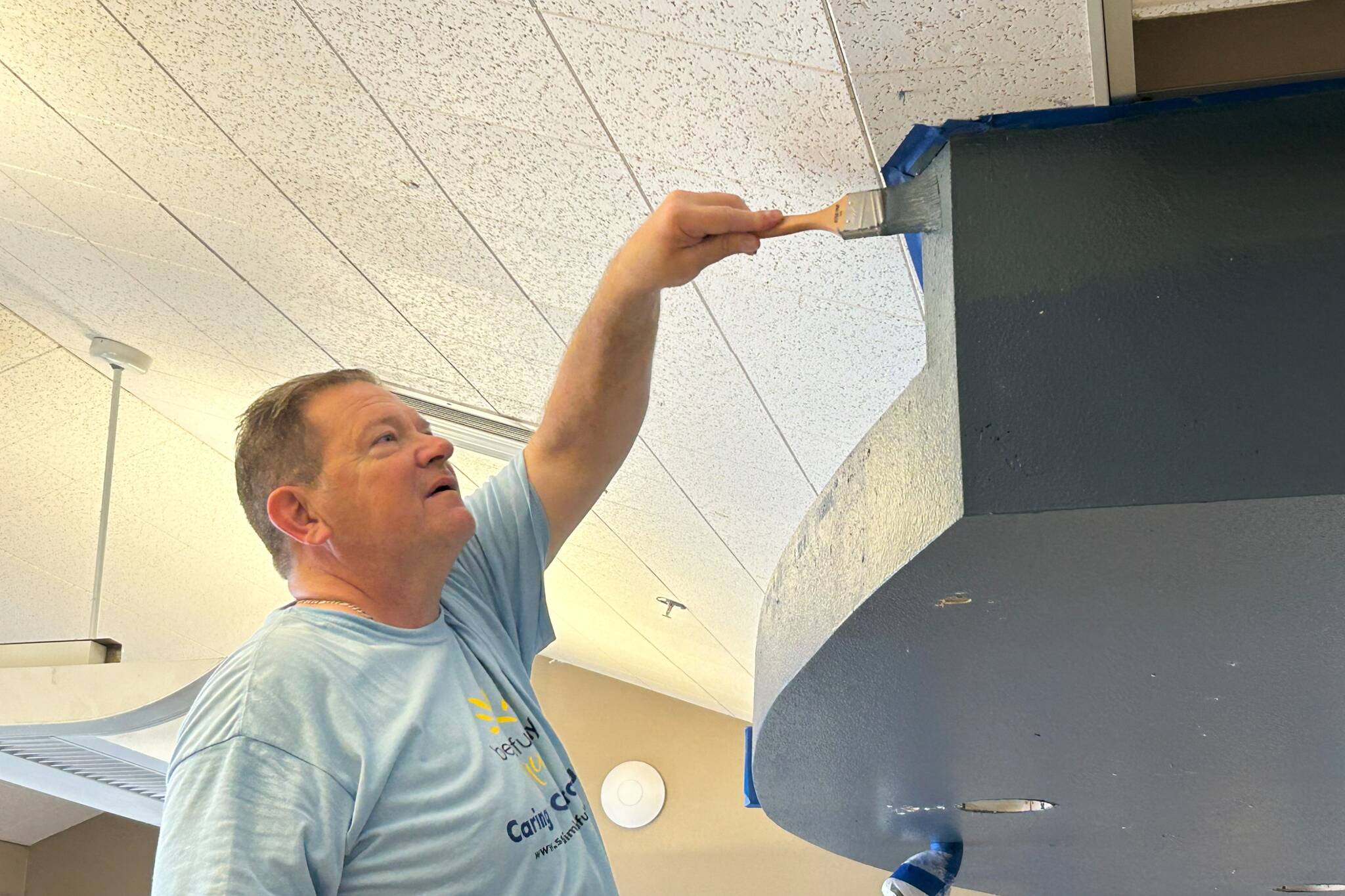 David Giller with Sequim Valley Foursquare Church paints a part of the Sequim Boys & Girls Clubs reception area on April 26 during the community project effort Sequim Beautiful Day. He was one of 150-plus volunteers from area churches to help with projects across Sequim.