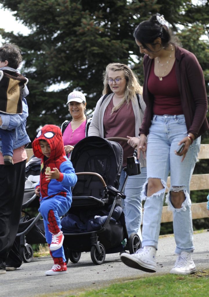 Sequim Gazette photo by Matthew Nash/ Jennifer Castillo walks along with her 3-year-old son Adriel in a Spider-Man costume during the Kids Parade. Castillo, a 2013 Sequim High grad, said her family just moved back to the area and they wanted to participate in Sequim events.