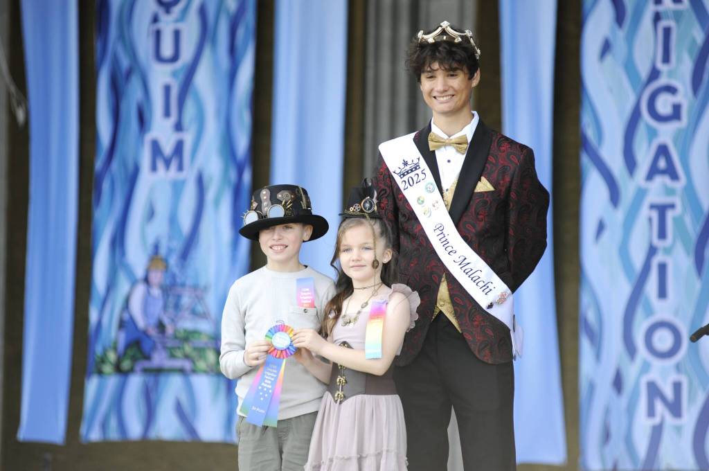 Sequim Gazette photo by Matthew Nash/ Braylen Williams and Adeline Gleason win the ribbon at the Kids Parade for the best festival theme costumes from festival prince Malachi Byrne.