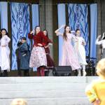 Sequim Gazette photo by Matthew Nash/ The Sequim High School operetta club performs a scene from Oklahoma! at the Family Fun Days on May 3 as 3-year-old Zephyr Lohman dances along in his firefighter costume.