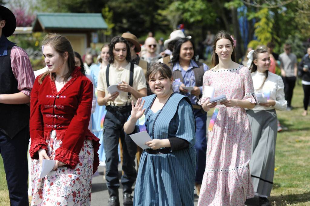 Sophia Treece and fellow cast members of Sequim High Schools Oklahoma! wave and hand out flyers to the show during the Kids Parade on May 3. The operetta plays four more shows at 7 p.m. Thursday-Saturday, May 8-10, and 2 p.m. Sunday, May 11 at Sequim High School.