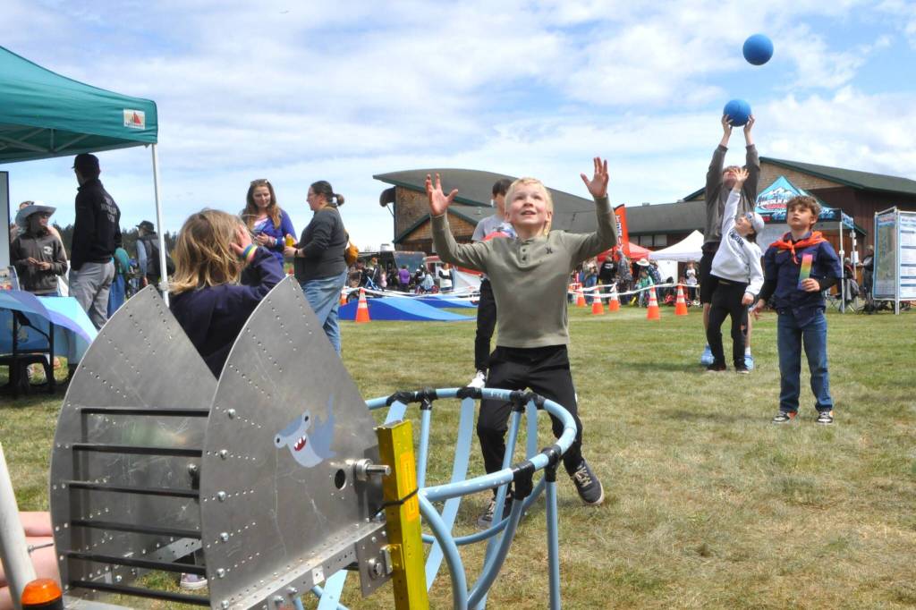 Sequim Gazette photo by Matthew Nash/ Children catch balls from Sequim Robotics Federations robot Jugglejaw on May 3. The robot and Sequim High School students will participate in the Grand Parade on May 10.