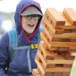 Sequim Gazette photo by Matthew Nash/ Melany Grogan of Sequim reacts to a move in a giant game of Jenga with her husband Nick and son Ernest at the Family Fun Days. The family participate in the Sequim Irrigation Festival every year, they said.