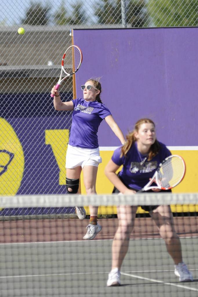 Sequim Gazette photo by Matthew Nash/ Sequims Sasha Yada makes a hit as doubles partner Kristine Prorok looks on during a match on May 2.