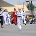 Sequim Gazette photo by Matthew Nash/ Skye Larsen, 8, of Port Angeles spins a bow staff with fellow members of White Crane Martial Arts during the Grand Parade.