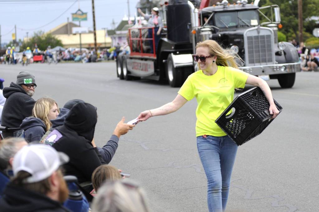 Sequim Gazette photo by Matthew Nash/ Sequim Food Bank volunteer Lily Neal hands out seeds to spectators of the Grand Parade.