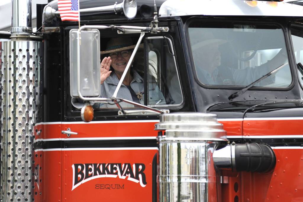 Sequim Gazette photo by Matthew Nash/ Trish and Dave Bekkevar wave to the masses during the Grand Parade while promoting the Sequim Logging Show.