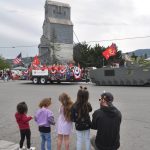 Sequim Gazette photo by Matthew Nash/ Cody Hanning, on right, watches the Grand Parade with his daughters, niece and family-friend as the Mt. Olympus Detachment of the Marine Corps League drives in front of the Sequim grain elevator.