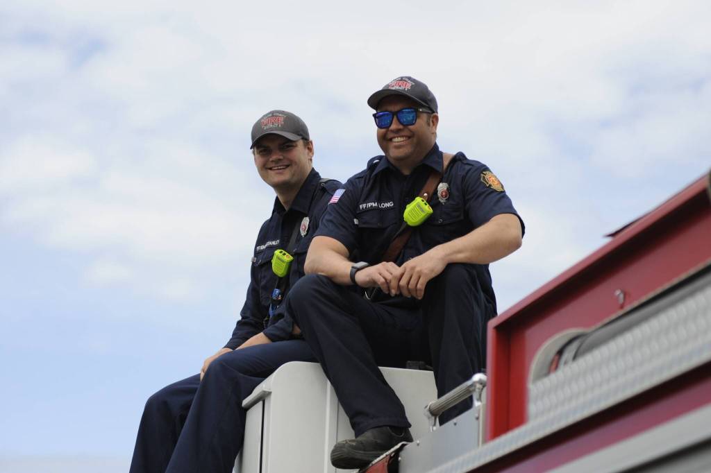 Sequim Gazette photo by Matthew Nash
Firefighters Jeremy Long and Jake Stanley with Clallam County Fire District 3 watch the Sequim Irrigation Festivals Grand Parade from atop their fire truck.