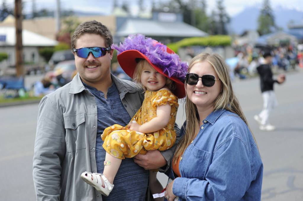 Sequim Gazette photo by Matthew Nash/ Port Angeles Riley and Sonja Hannam hold their two-year-old daughter Summer during the Grand Parade. The couple said they come watch every year.