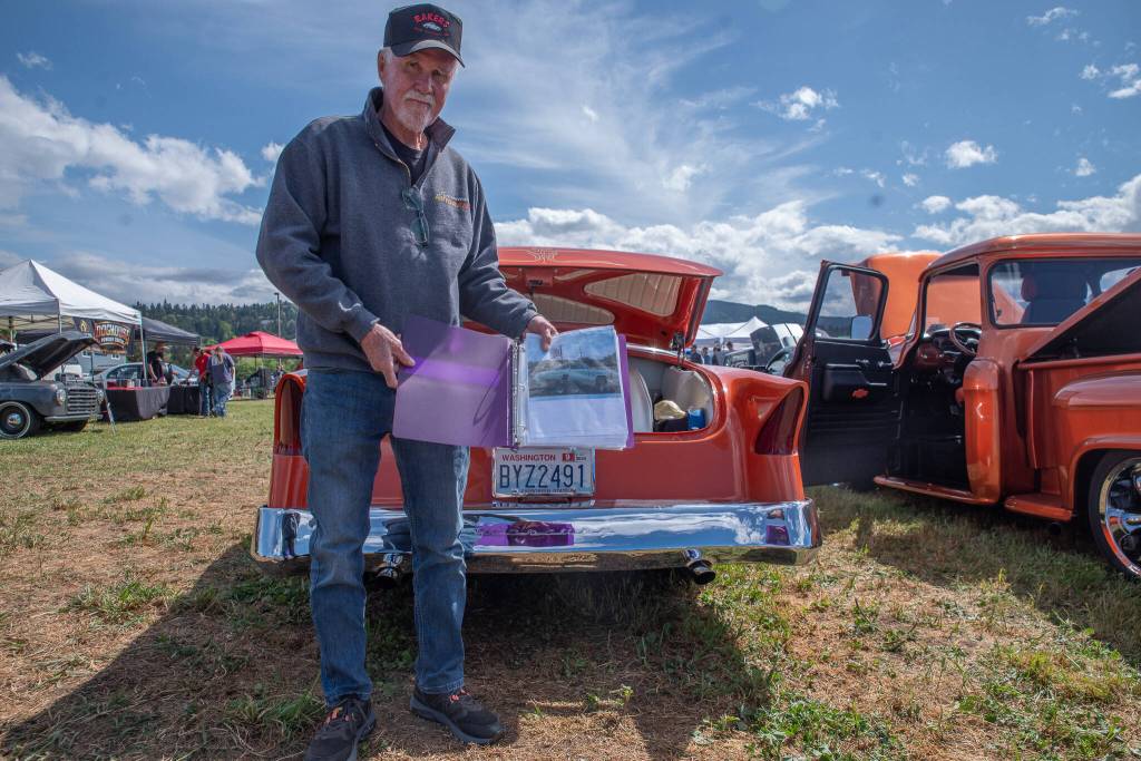 Sequim Gazette photo by Emily Matthiessen/ John Thomas shared his 1954 custom Mercury Monterey with a small block Chevy engine with folks visiting the Irrigation Festivals Car show. He holds in his hand a binder detailing the cars journey from a junkyard in San Andreas, CA. He built it out, including all the paint and body work and the upholstery was done by Rich Hawkins of Sutter Creek, Calif.