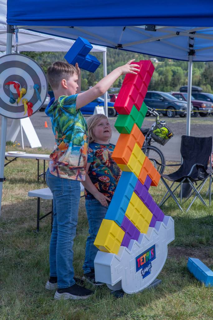 Sequim Gazette photo by Emily Matthiessen/ Duncan Burns, 11, and Sylas Plue, 7, work on a giant Tetris puzzle together at the Irrigation Festival Car Show.