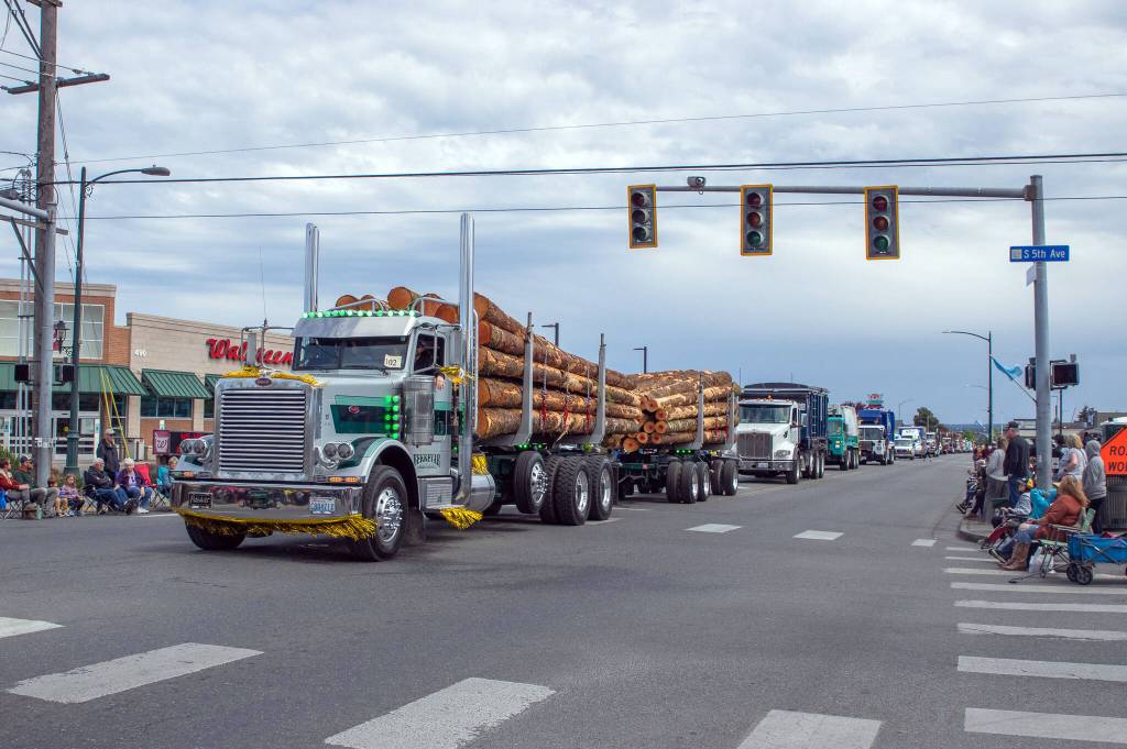 Sequim Gazette photo by Emily Matthiessen/ The Brekkavar family hauled a load of logs due to be auctioned at the Logging Show along Sequims Irrigation Festival Parade.