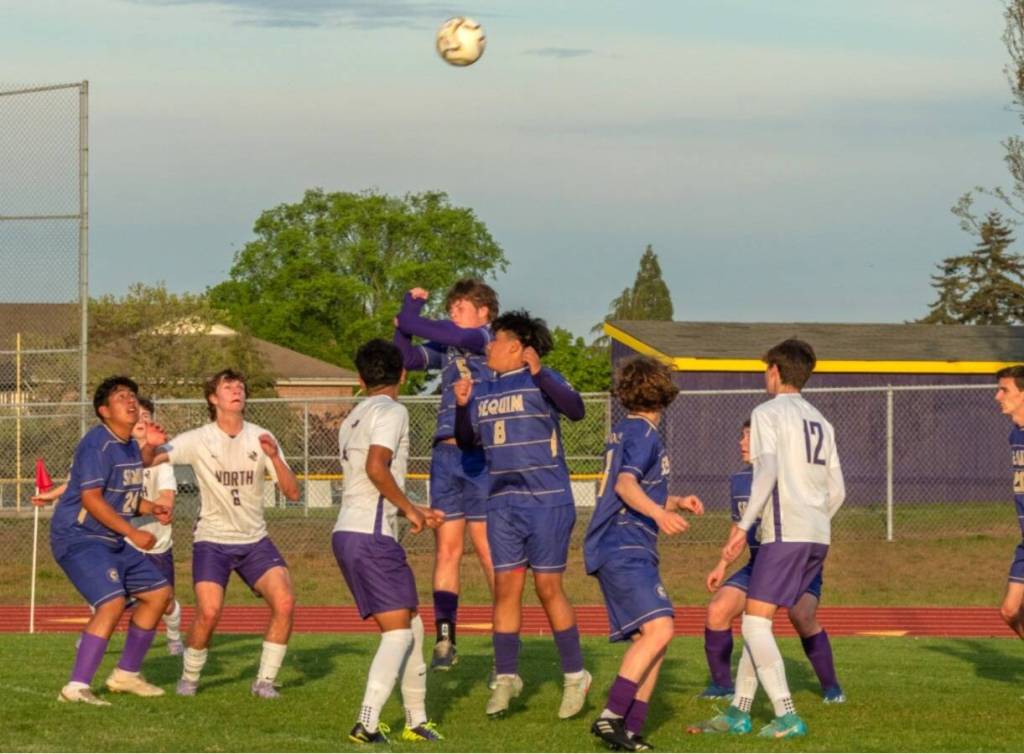 Sequim Gazette photo by Emily Matthiessen/ Sequim players head the ball near the goal against North Kitsap on May 6.