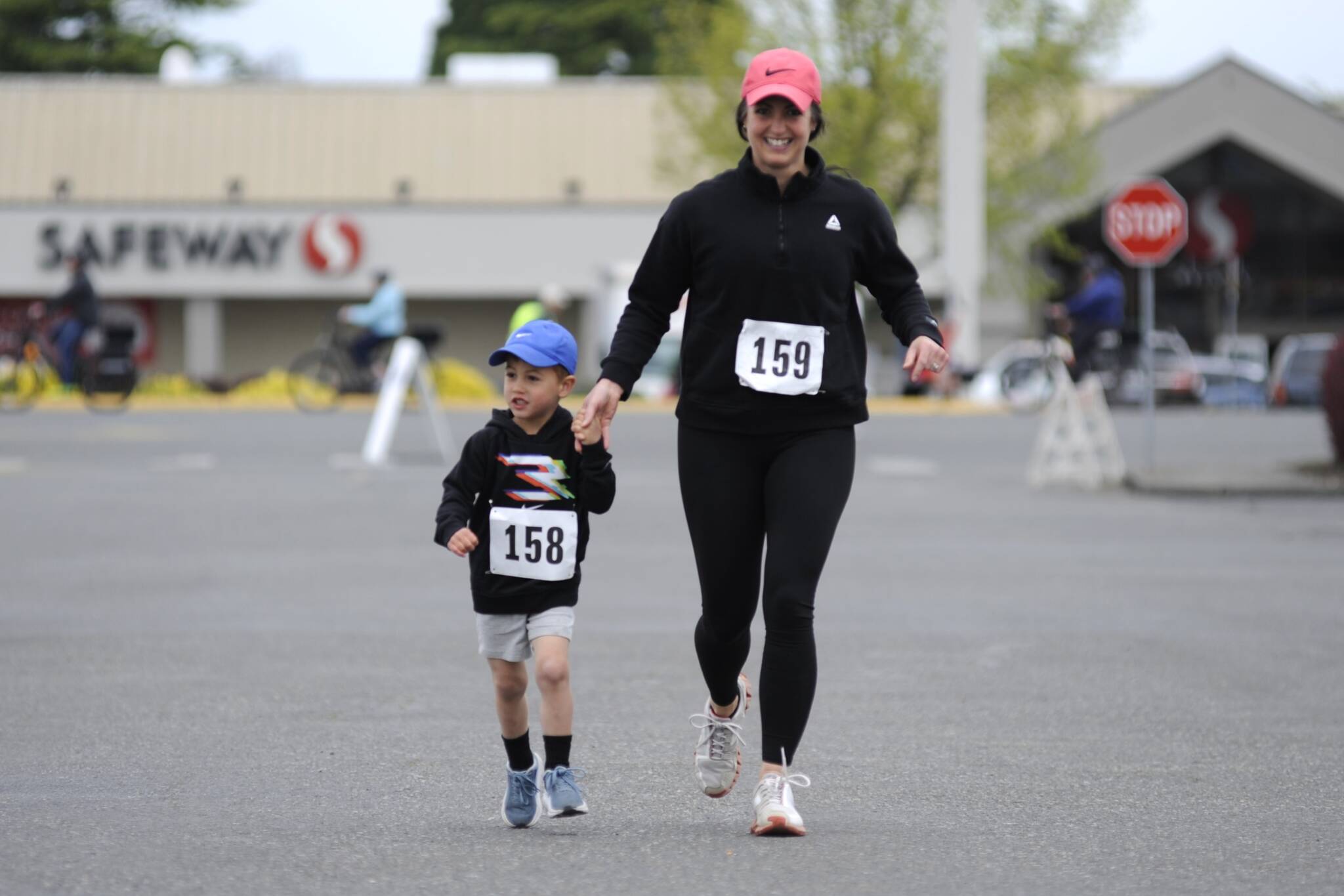 Sequim Gazette photo by Matthew Nash/ Mom Mallory Belanger of Port Angeles runs with 3-year-old son David the one-mile race during the Sequim Irrigation Festival on May 10. It was Davids first race, and it went great, Mallory said.