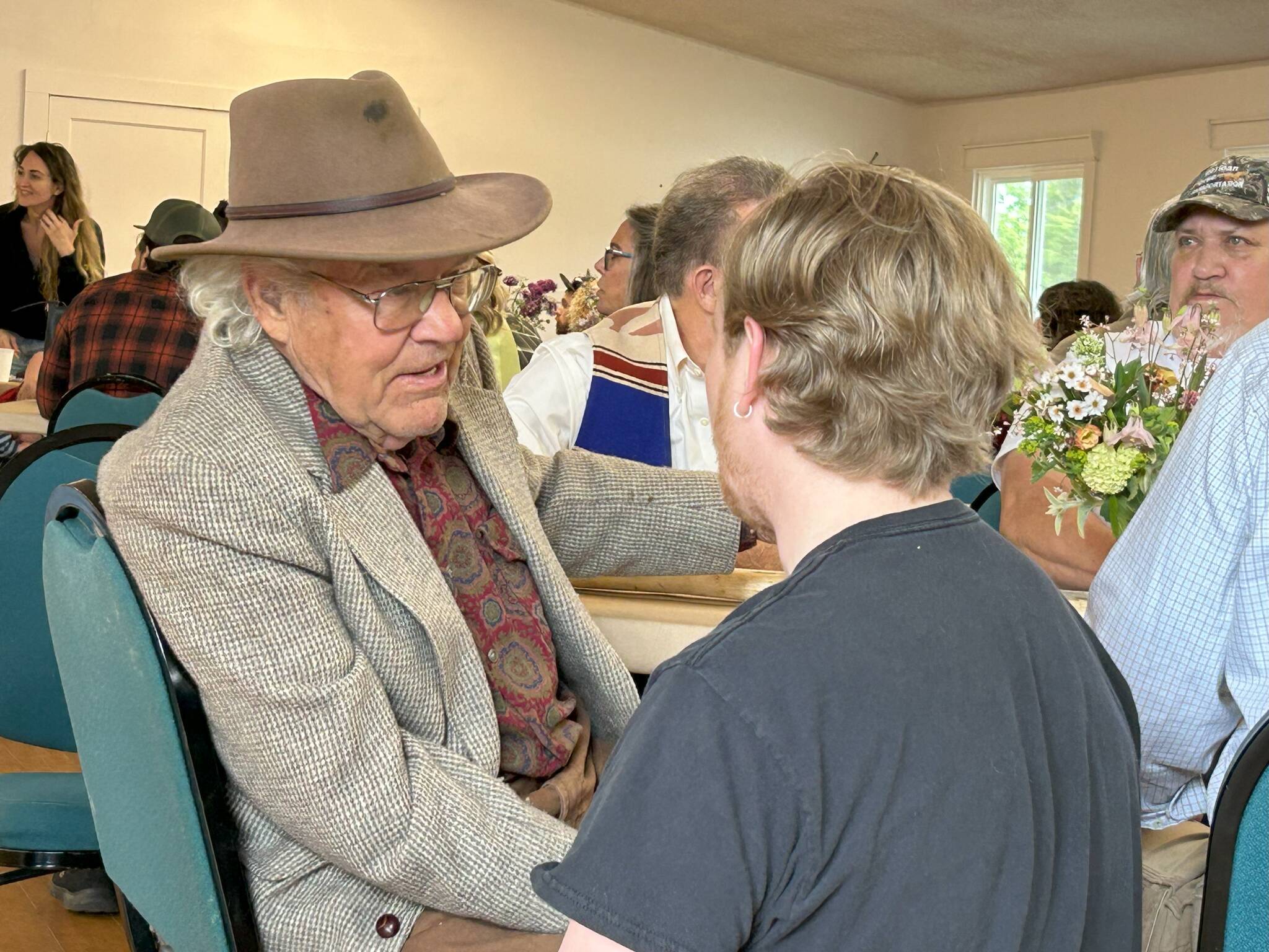 Sequim Gazette photo by Matthew Nash
Nash Huber greets visitors during a benefit concert and dinner on May 17 in the Sequim Prairie Grange that raised funds for his medical and legal expenses. He faces eviction from Delta Farm, a Dungeness farm he helped preserve in exchange to lease it through 2032. However, Washington Farmland Trust reports that Huber continues to have violations going against his lease agreement.