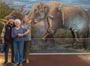 Sequim Gazette photo by Emily Matthiessen
From left, Clare Manis Hatler of Sequim, Charlene Gustafson and Vera Morgan paid a visit to the Sequim Museum and Arts at 544 N. Sequim Ave. last week. The trio have been friends for nearly 50 years after seven summers spent investigating the mastodon bones discovered on Manis Hatlers property by her late husband Manny Emanuel Manis. Gustafsons late husband, Carl Eugene Gus Gustafson, an associate professor at Washington State University, led research teams of graduate students at the Manis property in Happy Valley. One of those graduate students was Morgan, who is now retired and living in New Mexico after a career as an archeologist, including excavating a site for the U.S. Highway 101 bypass in Sequim. The women stand before the museums life-sized mural with some of the mastodons nearly 14,000-year-old bones.