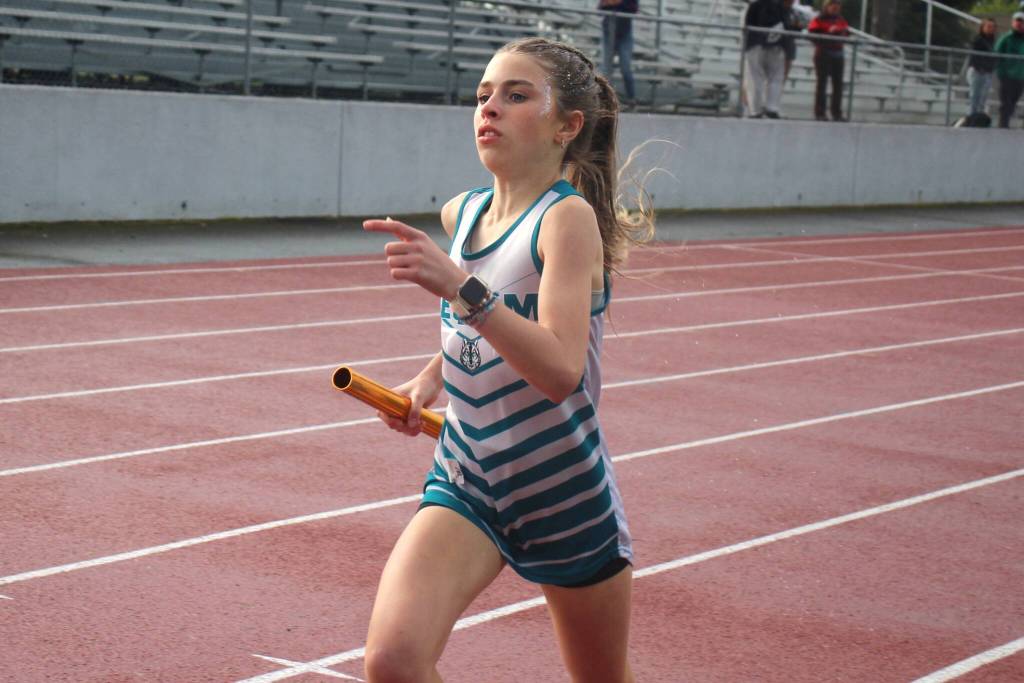 Photo by Selene Dorkin/ Emily Bair runs her leg of the 4X400-meters-relay on May 20. Her team took second behind Sequim teammates.