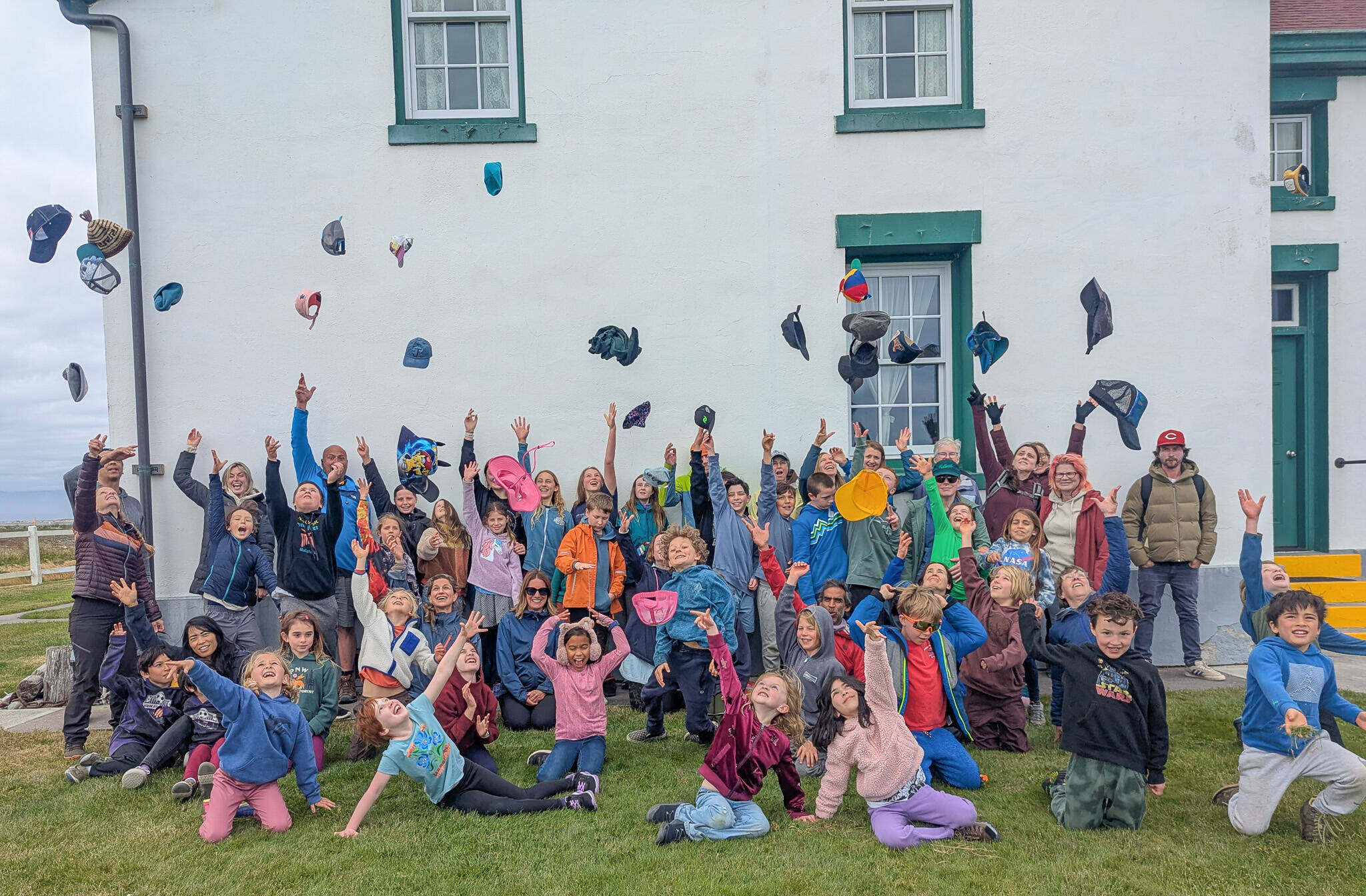Photo courtesy of Five Acre School/
Students, family members and teachers from Five Acre School throw their hats in the air after hiking approximately 5.5 miles from the trailhead at Dungeness National Wildlife Refuge to the New Dungeness Lighthouse. The children prepare for this end-of-the-year field trip by hiking every Wednesday with their classes.