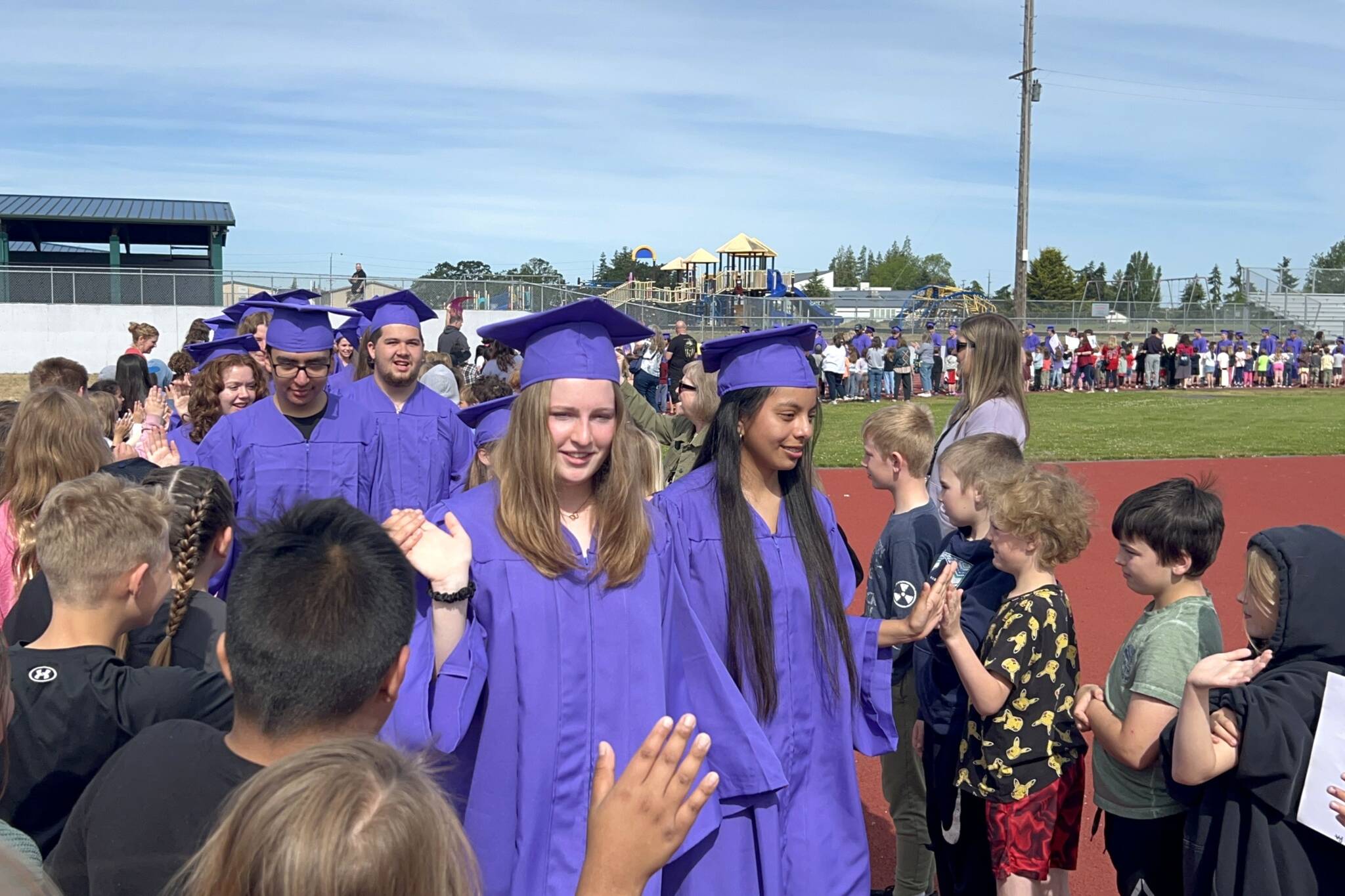 Sequim Gazette photos by Matthew Nash/
Keira Morey, Joanna Morales and other Sequim seniors high-five younger students during the annual Grad Walk on June 6.