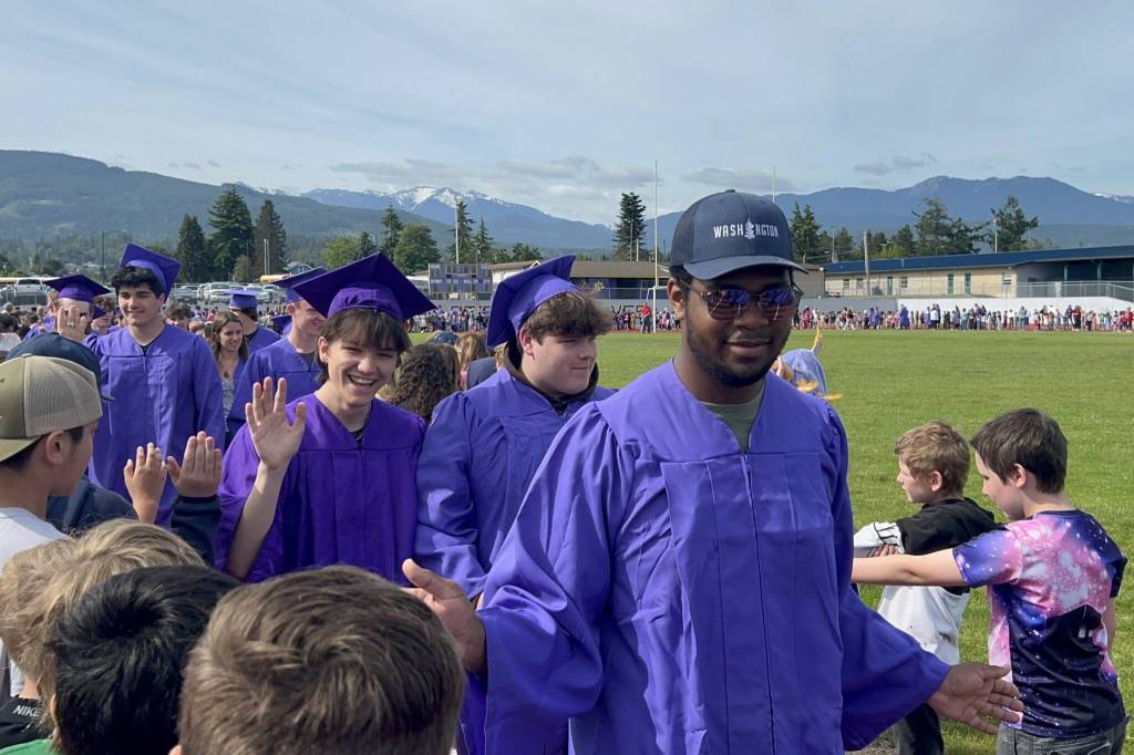Sequim Gazette photos by Matthew Nash/
Azuriah Sylvester, Ferris Cobb and Jibril Mohammed share high fives and smiles with younger students on June 6. The Sequim seniors graduated later in the night.