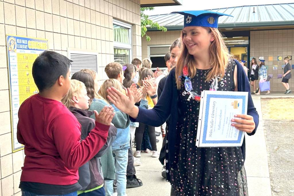 Sequim Gazette photo by Matthew Nash/ Fifth grader Kalliann Coleman high-fives third graders before the Moving On ceremony on June 12 that celebrated the students moving up to Sequim Middle School.