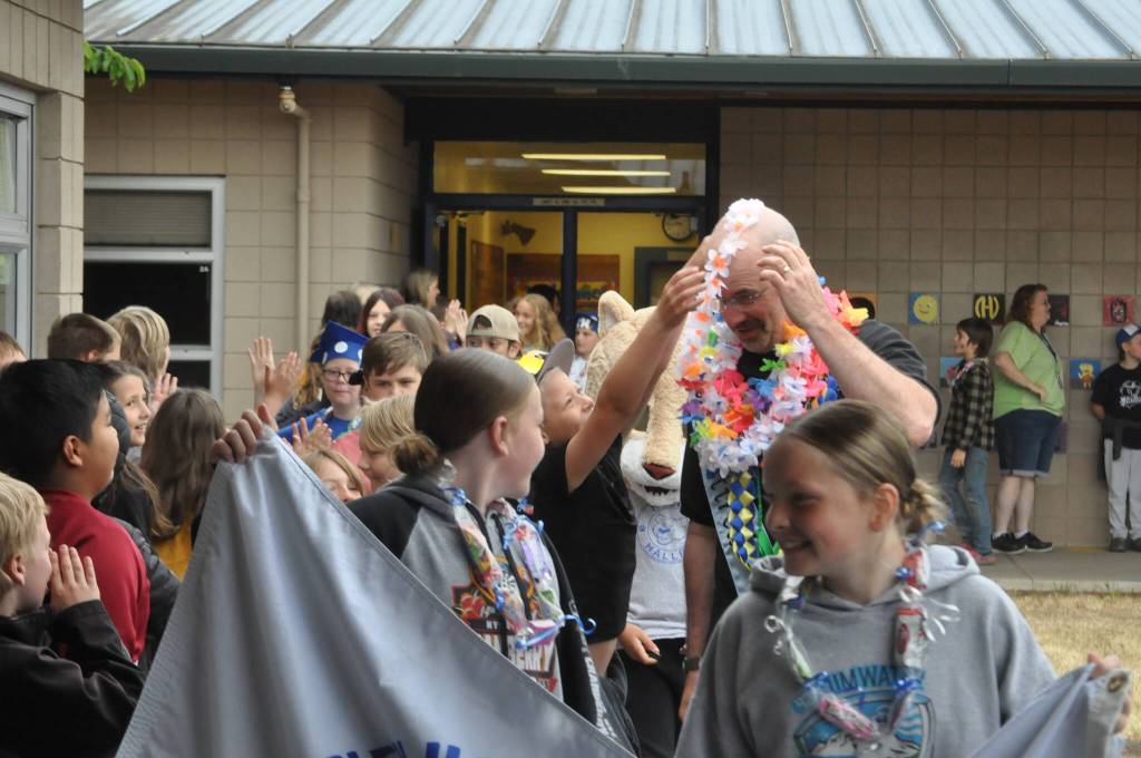 Sequim Gazette photo by Matthew Nash/ Retiring fifth grade teacher Eric Danielson is honored by students with several leis during the Fifth Grade Moving On ceremony.