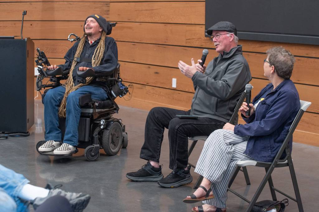 Ian Mackay, outdoors enthusiast and mobility activist, laughs at a joke made by Terry Gallagher, board member for the nonprofit Ians Ride while author Karen Polinsky looks on at the Dungeness River Nature Center.