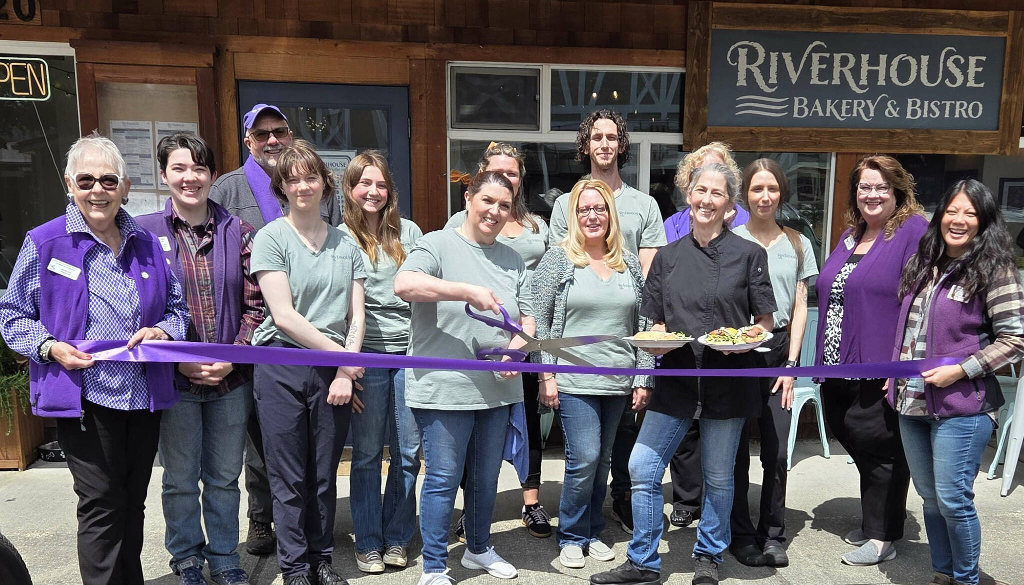 Photo courtesy Sequim-Dungeness Valley Chamber of Commerce/
Ambassadors with the Sequim-Dungeness Valley Chamber of Commerce join Riverhouse Bakery & Bistro for a ribbon cutting on Friday, June 20, to celebrate their new dinner service offered from 4-8 p.m. on Friday and Saturday. Owner Denise Ferguson, surrounded by her staff, holds plates containing the bistros new Salmon Wellington and an open-face steak sandwich. Guests were invited to sample menu items, including steak gorgonzola alfredo.